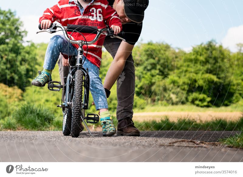 Felix lernt Fahrradfahren mit Papa erstes Fahrrad Kinderrad aufsteigen Kindheit lernen erfahren erleben Familie Vater erklären Familie & Verwandtschaft Mann