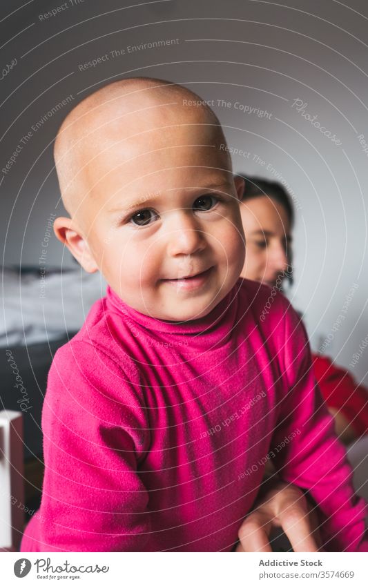 Entzückender kleiner Junge spielt zu Hause mit Spielzeug Spielzimmer heimwärts charmant neugierig Kleinkind lässig rosa Hemd Kind Stock Aktivität spielerisch