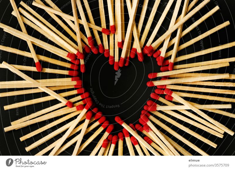 Photochallenge I Streichhölzer auf schwarzem Grund - rote Streichholzköpfe bilden ein Herz, weitere Hölzer liegen obenauf Streichholzkopf Unordnung Liebe