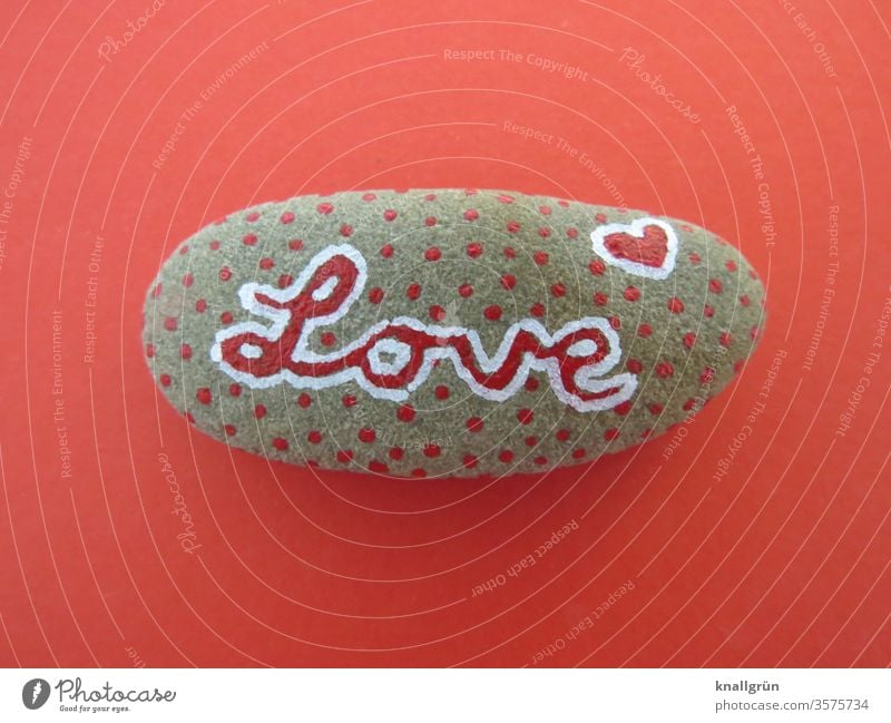 Rot gepunkteter Glücksstein mit dem Schriftzug „Love“ auf rotem Grund Liebe Kreativität Stein Romantik Graffiti Herz Verliebtheit Gefühle Zeichen Schriftzeichen