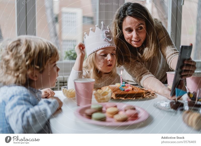 Fröhliches kleines Mädchen macht während der Geburtstagsfeier einen Videoanruf auf Tablet Mutter Tochter feiern Spaß Glück abgelegen heimwärts Entfernung