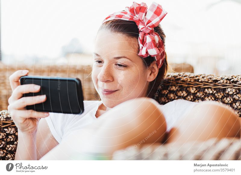 Junge Frau sieht Inhalte auf Smartphone jung Technik & Technologie Telefon WiFi Drahtlos Drahtlose Technologie benutzend Beteiligung Gerät Mädchen modern Sommer