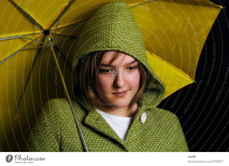any Frau Regenschirm gelb grün Mantel Kapuze schwarz Gesicht Blick