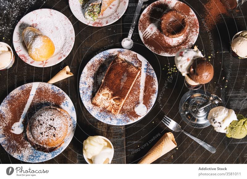 Set mit verschiedenen schmackhaften Desserts auf dem Tisch lecker süß Gebäck tiramisu Schokolade Kuchen Muffin Kulisse Kakao Zucker Pulver dienen Konditorei