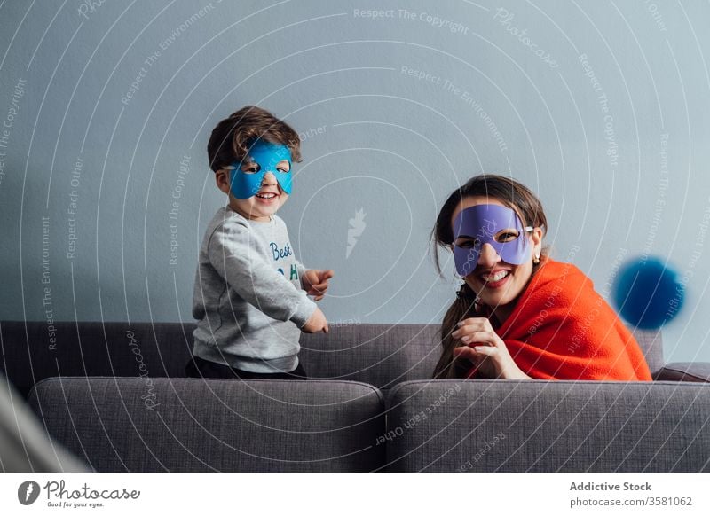 Kreative Mutter und Sohn in Superheldenmasken zu Hause spielen Mundschutz Spiel kreativ so tun, als ob Spaß haben spielerisch heiter wenig Wochenende Junge Kind