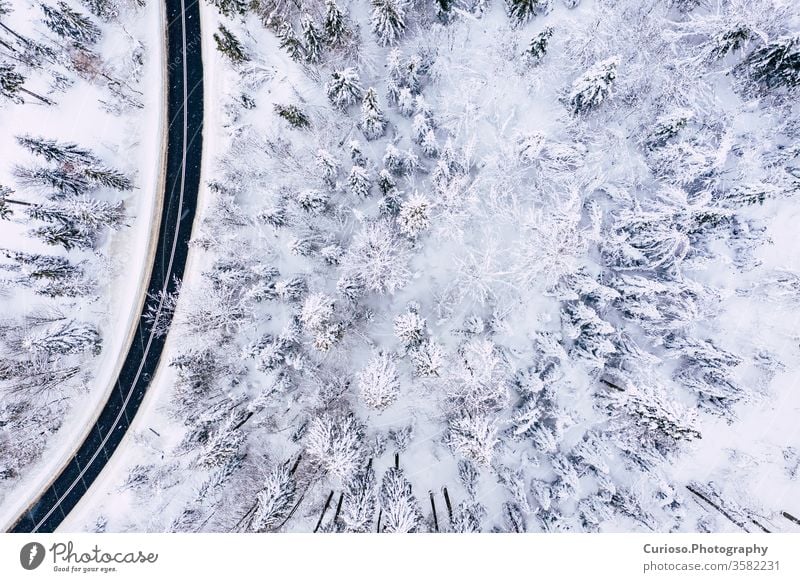 Kurvige, kurvenreiche, kurvenreiche Straße in schneebedecktem Wald, Luftaufnahme von oben. Winterlandschaft. Ansicht Antenne Top Dröhnen Schnee Landschaft Natur