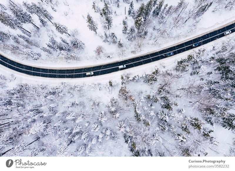 Kurvige, kurvenreiche, kurvenreiche Straße in schneebedecktem Wald, Luftaufnahme von oben. Winterlandschaft. Ansicht Antenne Top Dröhnen Schnee Landschaft Natur