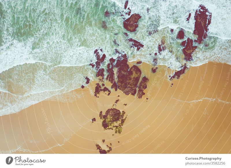 Luftaufnahme zu den Meereswellen. Gelber Sandstrand. Blauer Wasserhintergrund. Foto von oben von einer Drohne gemacht. Ansicht MEER Wellen Top winken Strand