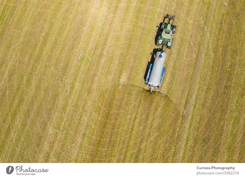 Luftaufnahme eines Ackerschleppers beim Pflügen und Spritzen auf dem Feld.  Landwirtschaft. Ansicht von oben. Mit Drohne aufgenommenes Foto. Antenne Maschine