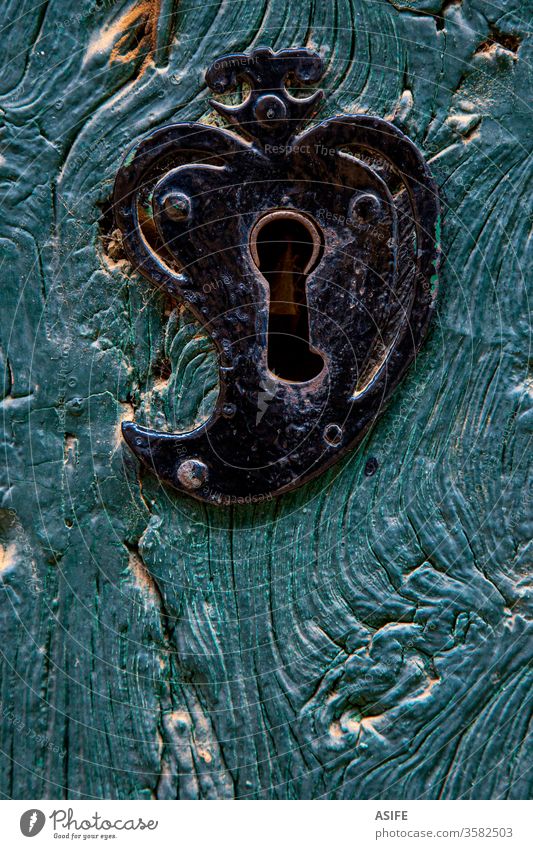 Altes herzförmiges Türschloss an einer blauen Holztür Schloss Herz Form Herzform Detailaufnahme abschließen alt rustikal bügeln getrieben gemalt Vorderseite