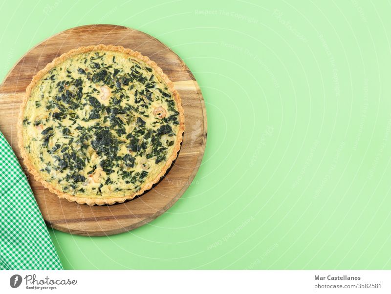 Gemüse-Quiche auf grünem Hintergrund. Leerzeichen kopieren. Spinat grüner Hintergrund Küchentisch Textfreiraum Draufsicht Lebensmittel Käse gebacken Mahlzeit