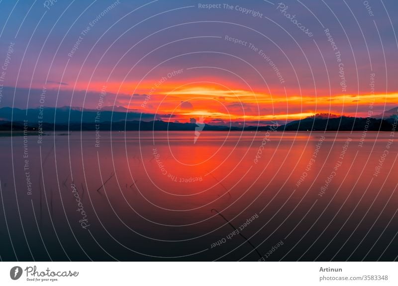 Roter und oranger Sonnenuntergangshimmel am Berg und am See. Wunderschöner Abendhimmel. Majestätischer Sonnenuntergangshimmel. Hintergrund der Natur. abstrakt