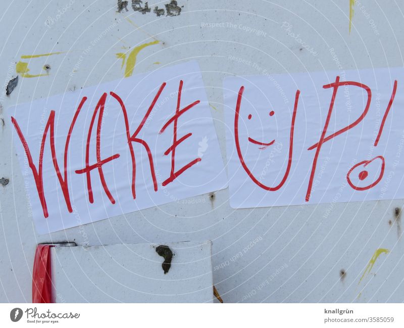 Zwei weiße Blatt Papier „WAKE UP!“ mit einem Smiley mit rotem Stift geschrieben kleben an einer alten, weißen Metalltür Graffiti aufwachen wach werden