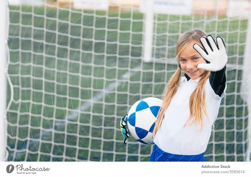 Glückliche junge Spielerin mit Ball in Fussballarena im Sportstadion Mädchen Fußball Feld Uniform Kind Club Kindheit Athlet Gerät Lächeln Schulmädchen heiter