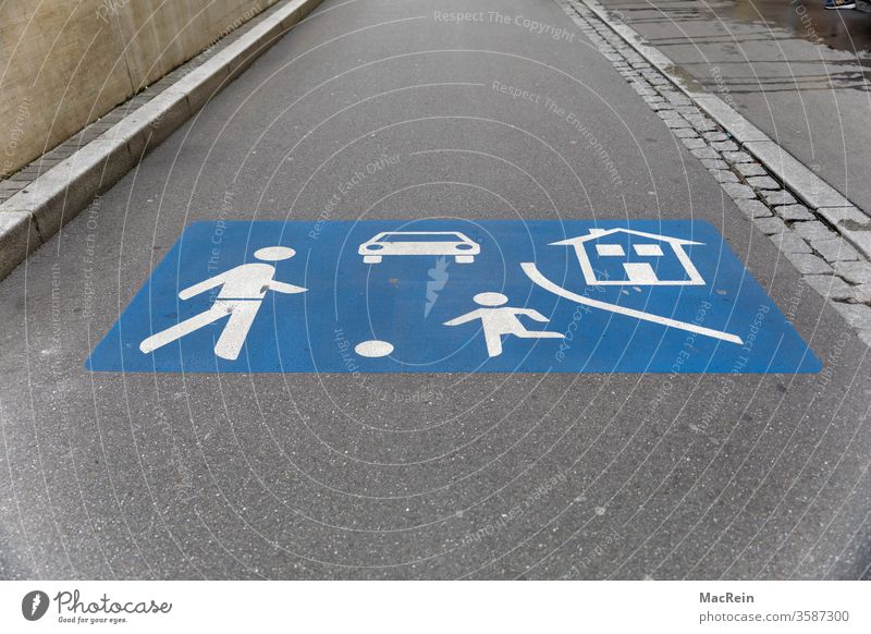 Verkehrssymbol in einer Spielstrasse spielstrasse grafk verkehrszeichen blau weiss aufgemalt niemand textfreiraum vorsicht kinder achtung