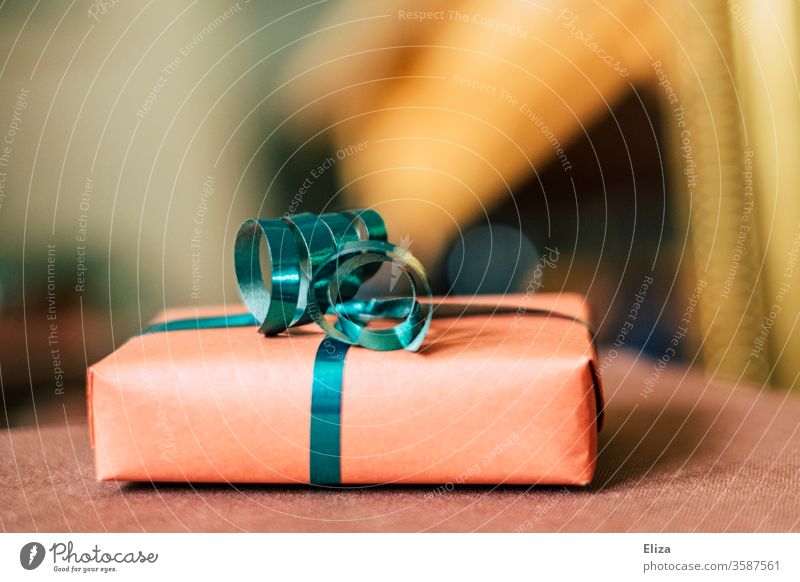 Ein Geschenk mit Geschenkband zu Weihnachten oder zum Geburtstag vor unscharfem Hintergrund. schenken Muttertag verpackt Weihnachten & Advent Feste & Feiern