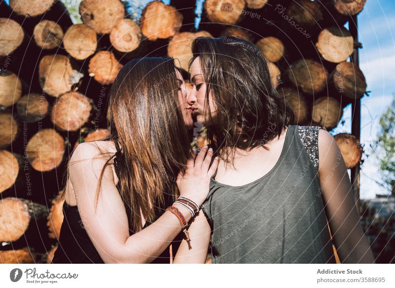 Junges lesbisches Paar küsst sich Frauen Kuss rustikal Wand Totholz Sommer gleichgeschlechtlich Sommerzeit tagsüber jung Angebot Homosexualität lgbtq schwul