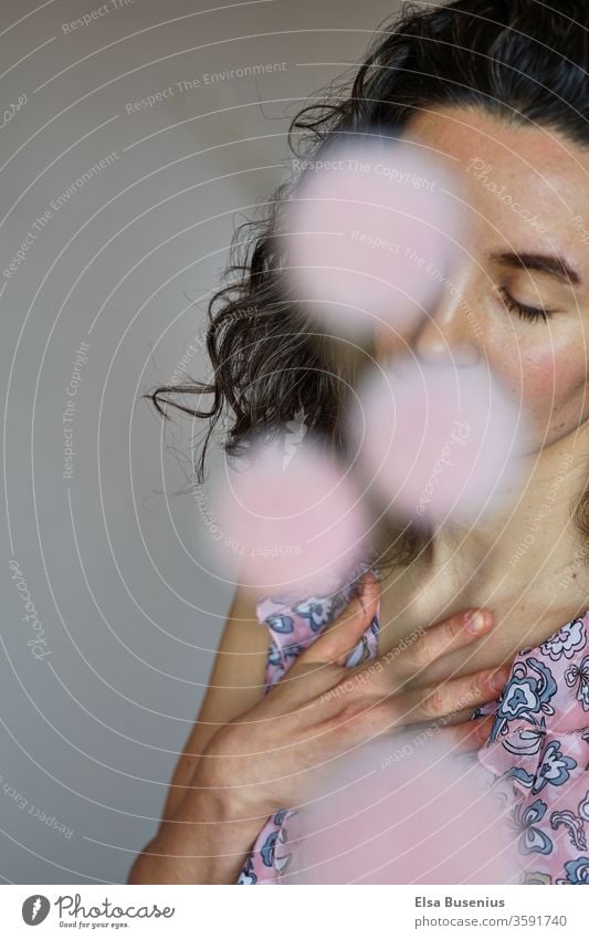 Frau mit geschlossenen Augen, Blumen verdecken ihren Mund und ein Auge Studioaufnahme Farbfoto Scham Gefühle schwarz 30-45 Jahre Erwachsene feminin Mensch