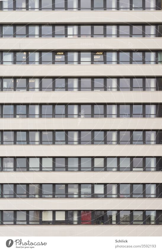 Fassade eines Bürogebäudes mit vielen Fenstern frontal Tag Neonlampen modern Quadrate Rechtecke Alufenster Stockwerke Hochhaus Beton ohne Himmel grau schwarz
