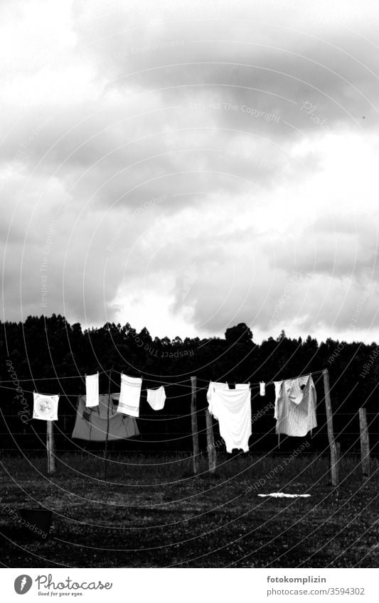 schwarz weisse Wäscheleine draußen bei bewölktem Himmel Waschtag trocknen Häusliches Leben Wäsche waschen Sauberkeit Haushalt aufhängen Bekleidung