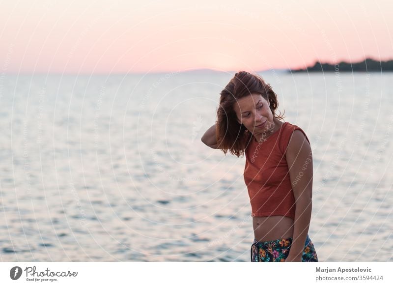 Junge Frau genießt Sonnenuntergang am Strand lässig Glück Lifestyle Sonnenaufgang MEER Meer Wasser reisen Urlaub genießend Feiertag Sommer Freiheit im Freien