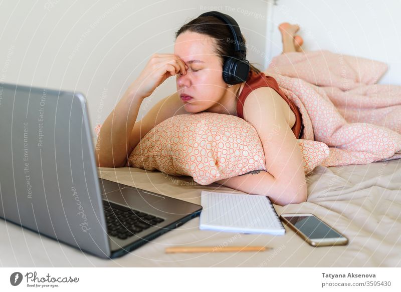 Frau, die von zu Hause aus in ihrem Bett arbeitet. Müdigkeit und Stress heimwärts Arbeit Computer Laptop Lernen müde Schlafzimmer arbeiten Business