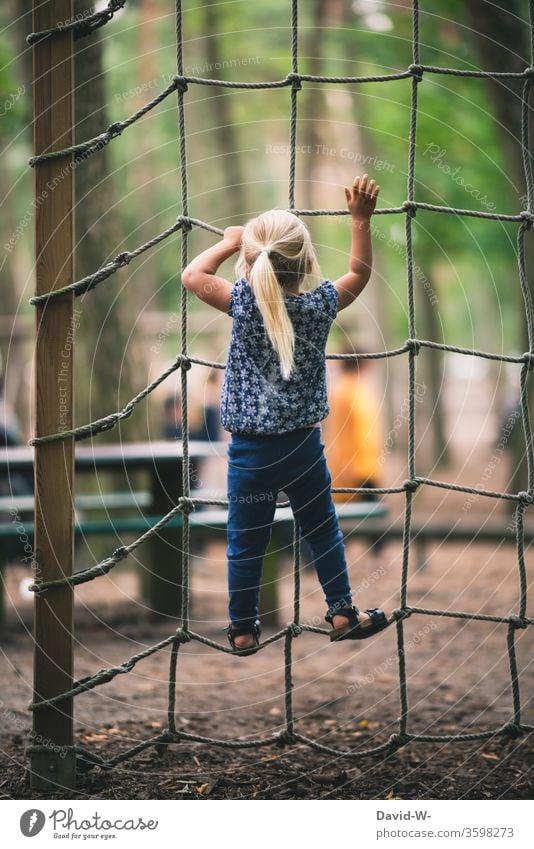 Spielplatz - Mädchen klettert ein Kletternetz hoch spielplatz freude spaß Euphorie mutig Mut festhalten festhaltend verantwortung mutig sein hoch hinaus
