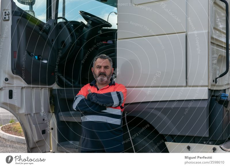 Lkw-Fahrer posiert mit offener Tür neben dem Lkw-Fahrerhaus Lastwagen Mann erfahrungen professionell Veteran hohe Sichtbarkeit Kabine Verkehr Transport Versand
