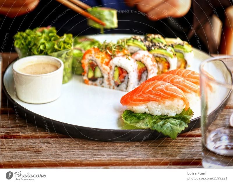 Sushi- und Nigiri-Platte nach japanischer Art im Restaurant Oudoors, Weichzeichner Lebensmittel Japanisch Lachs rollen Teller Salatbeilage asiatisch Reis