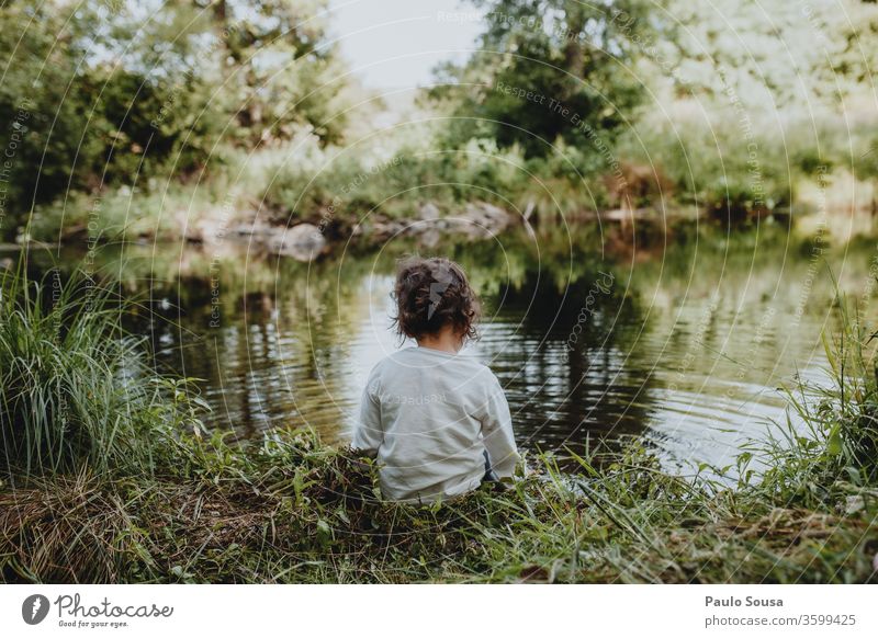Kleines Mädchen am Fluss sitzend Kind Rückansicht Kaukasier 1-3 Jahre Mensch Farbfoto Kindheit Außenaufnahme 3-8 Jahre Kleinkind Tag Spielen beschaulich Sommer