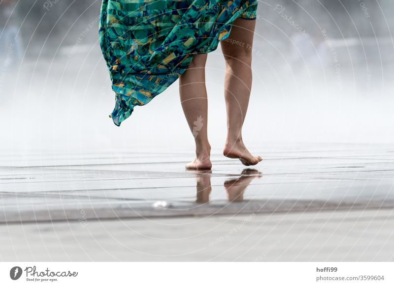 die junge Frau geht Barfuß über eine nasse Fläche - der Sprühnebel des Miroir d'eau sorgt für eine willkommene Abkühlung Fuß Beine Zehen Haut Wasser Schatten
