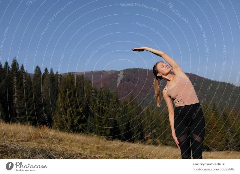 Junge Frau macht Dehnungsübungen in der Natur in den Bergen. Sportlerin beim Üben von Yoga-Pose in Leggins. schöne Waldlandschaft Zen sportlich Fitness