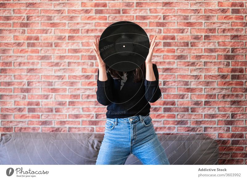 Anonyme junge Frau hält mit ihren Händen ein schwarzes Vinyl schön Mädchen Musik Disco Mode Klang Hintergrund Porträt Person Audio Menschen Entertainment