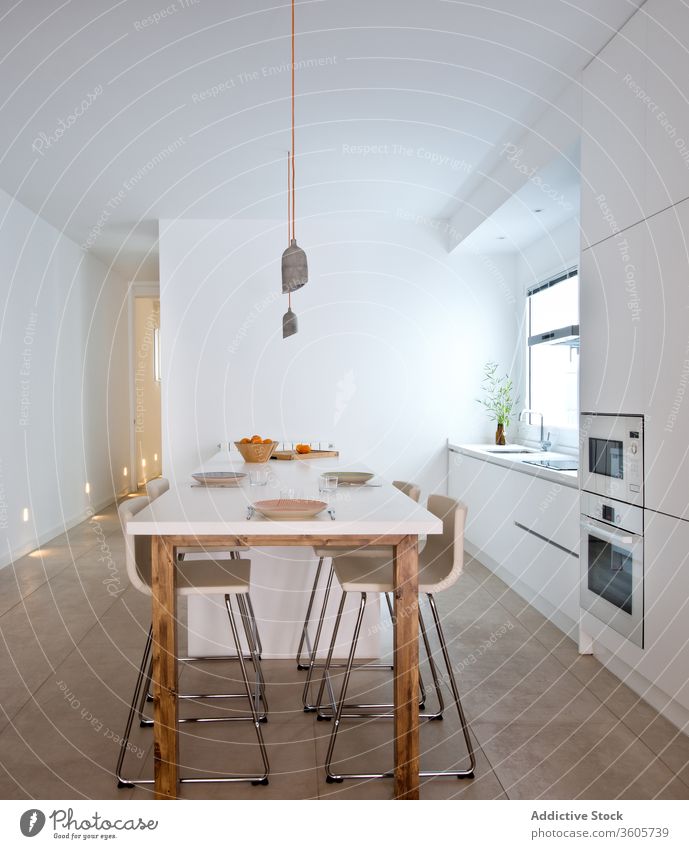 Interieur einer hellen Küche in einer modernen Wohnung Innenbereich Tisch Zeitgenosse sehr wenige skandinavisch Appartement einfach geräumig Stil Dekor Design