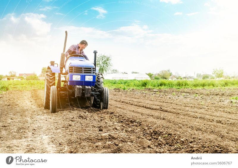 Landwirt bearbeitet Boden auf einem Traktor. Boden mahlt, krümelt und mischt. Oberfläche lockern, Land für die weitere Bepflanzung kultivieren. Landwirtschaft, Anbau von Biogemüse. Agroindustrie, Landwirtschaft.