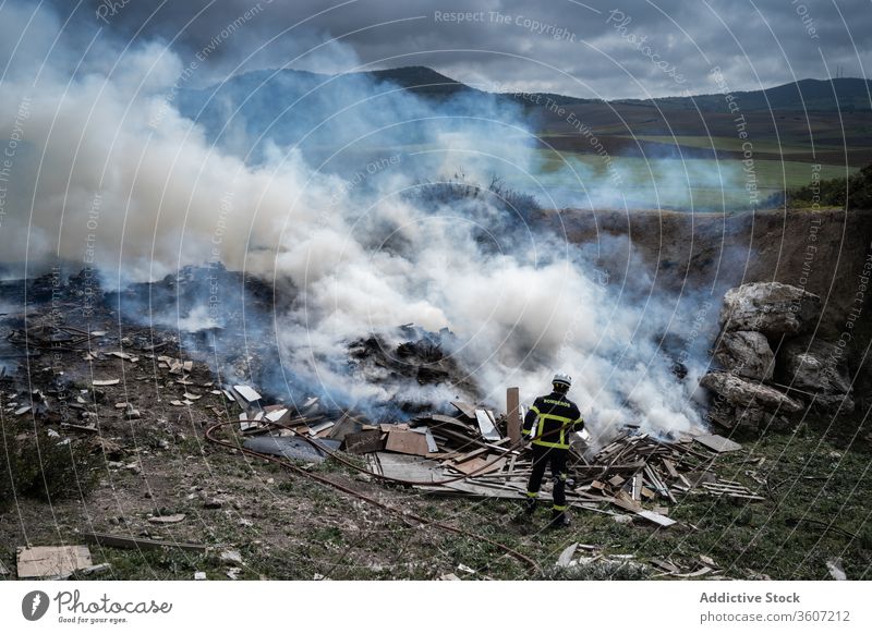 Feuerwehrmann löscht Feuer mit Wasser Mut Schlauch löschen Rauch ausmachen Uniform männlich behüten Arbeit Gerät Job stehen Beruf Schutzhelm Sicherheit Arbeiter