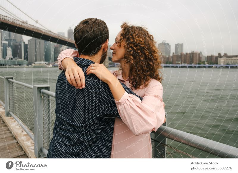 Glückliches Paar umarmt sich am Damm Umarmen Spazierweg schlendern Großstadt Stauanlage Partnerschaft Fluss Umarmung Brooklyn Bridge New York State amerika