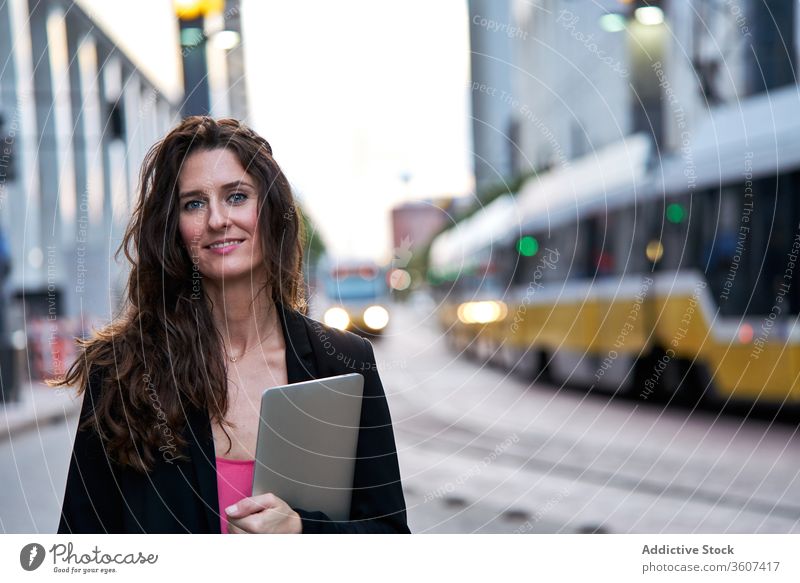 Geschäftsfrau mit Laptop auf der Straße in der Stadt Unternehmer Großstadt selbstbewusst Stadtbild formal gut gekleidet professionell Frau Business heiter