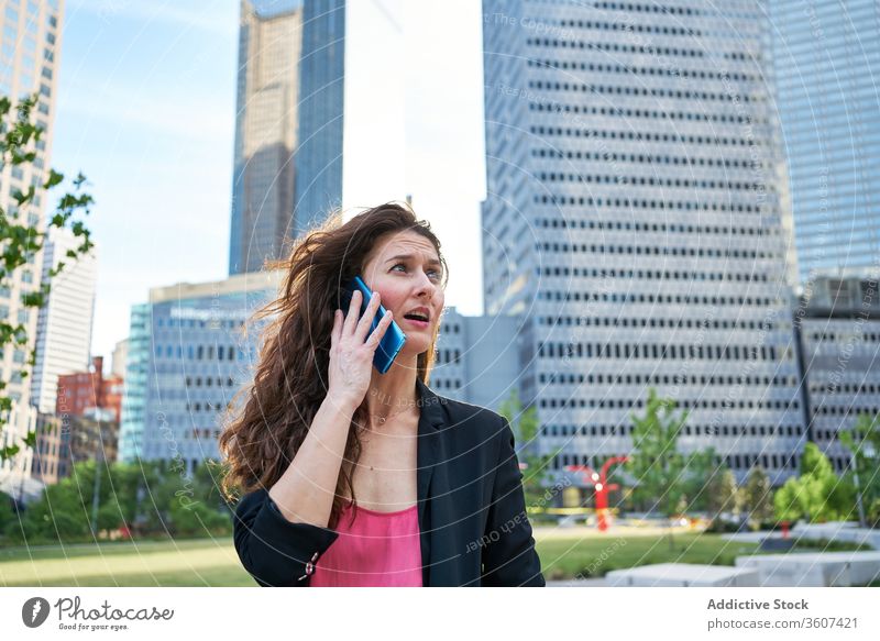 Erwachsene Frau mit Smartphone in der Stadt Geschäftsfrau reden Großstadt Inhalt elegant sprechen Wolkenkratzer Business benutzend Zentrum Jacke Arbeit
