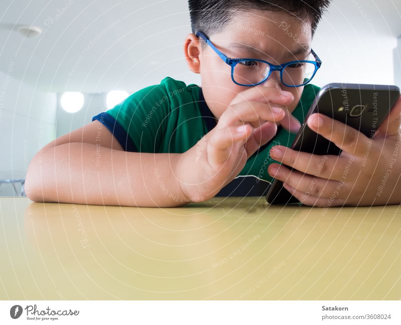 Ernsthafter Junge spielt auf Smartphone Kinder ernst Telefon spielen Spiel Schweiß asiatisch Hand Technik & Technologie klug jung aufrichtig Internet Mobile