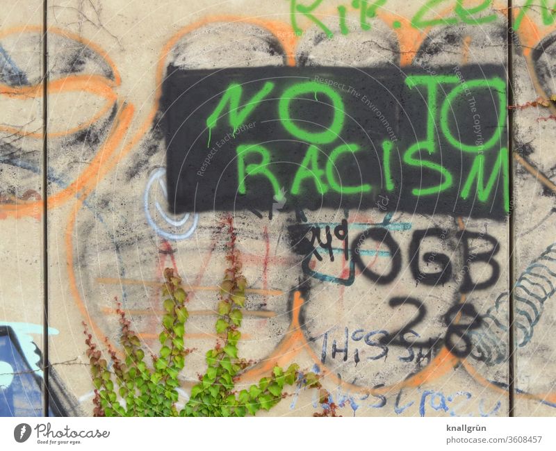 Grünes Graffiti „NO TO RACISM“ auf schwarzem Rechteck auf einer bunten Wand Rassismus Politik & Staat Gesellschaft (Soziologie) protestieren Protest