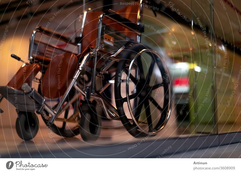 Verschwommener leerer Rollstuhl in der Nähe des Aufzugs in einem Privatkrankenhaus für Dienstpatienten und Behinderte. Medizinische Ausrüstung im Krankenhaus zur Unterstützung von behinderten Menschen. Rollstuhl mit Rädern für die Patientenversorgung.