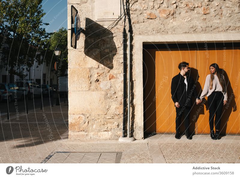 Glückliches liebendes Paar steht neben der Tür eines alten Gebäudes Liebe Zusammensein jung Partnerschaft romantisch Händchenhalten Eingang verwittert Stein