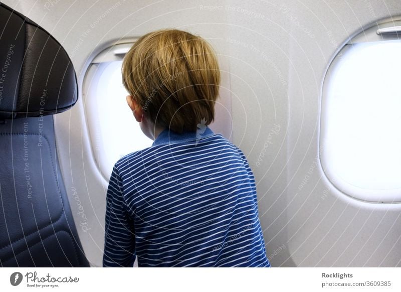 Kleiner Junge schaut aus dem Fenster eines Flugzeugs Ebene Kind Blick Familie reisen wenig Passagier Feiertag Fluggerät Urlaub Air Tourismus klein Menschen jung