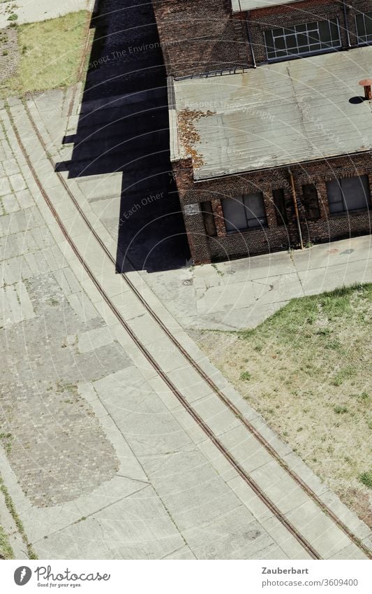 Blick auf die Schienen einer Werksbahn von oben mit alten Fabrikgebäuden Bogen Eisenbahn Gebäude Gleise Industrie historisch Industriedenkmal Industrieanlage
