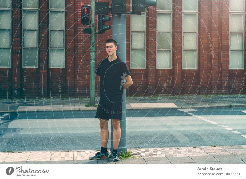 Porträt eines einsamen jungen Mannes, der an einer roten Ampel steht Straße Jugendlicher schön Junge Gebäude lässig Kaukasier selbstbewusst Kultur Zukunft