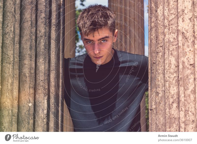 Porträt eines jungen Mannes, der zwischen antiken Säulen steht Teenager Lifestyle Architektur schön schwarz blau Junge lässig Kaukasier Kleidung Konzentration