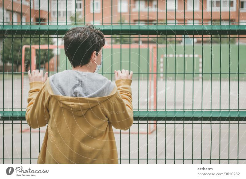 Rückansicht eines traurigen Kindes, das auf den Fussballplatz schaut Coronavirus Virus Seuche covid-19 Fußball Tor Ball Spielplatz Spielzeit Pandemie Quarantäne