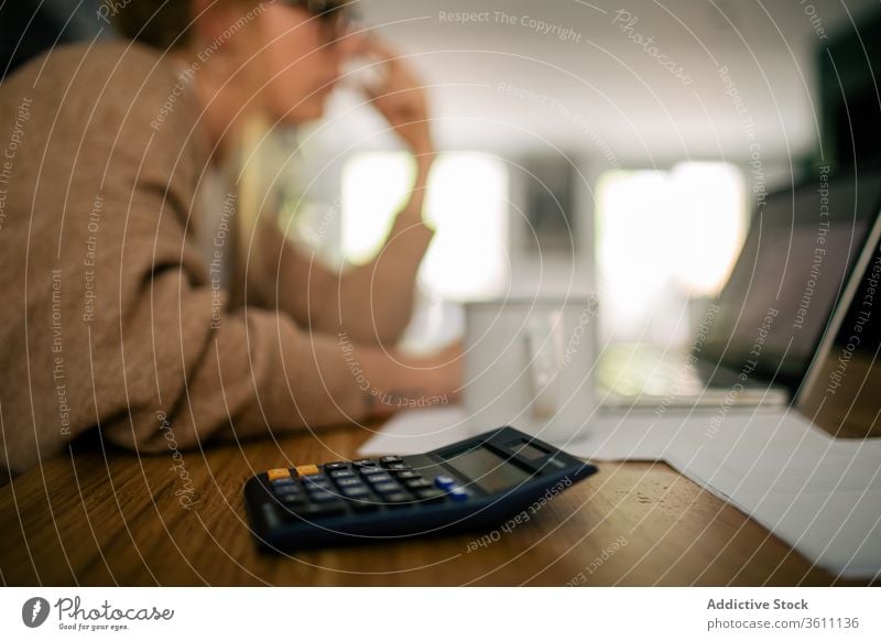 Buchhalterin, die einen Taschenrechner benutzt und aus der Ferne arbeitet Rechner berechnen Frau freiberuflich abgelegen Papierkram Bericht finanziell