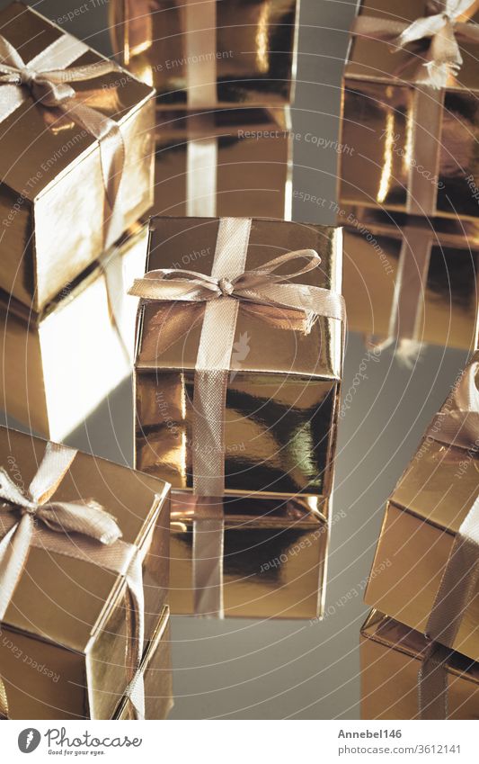 Gruppe von goldfarben glitzernden Geschenkschachteln auf grauem Hintergrund mit Spiegelung. Gruppe von goldenen Geschenkschachteln für Geschenk, Überraschung, Geburtstag, Weihnachten Konzept
